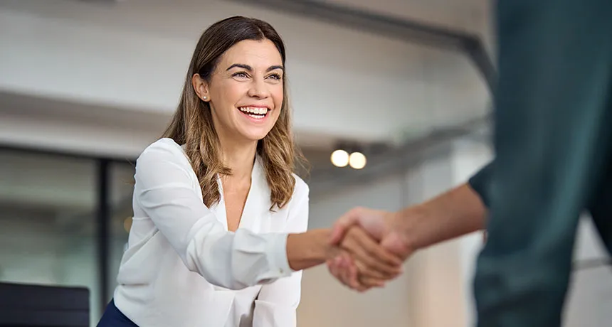 ESG und ISO Branchenlösung Bauwirtschaft, Mehrwert finanzierungsrelevante Nachweise, Geschäftsfrau schüttelt Hand und ist erfreut