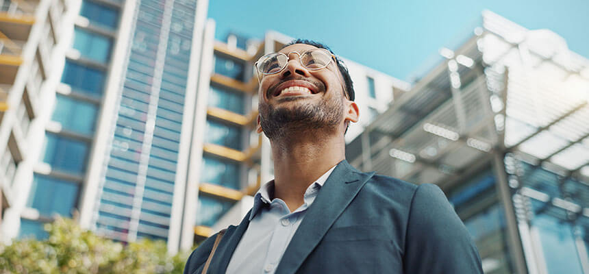 Geschäftsmann vor modernen Bürogebäuden als Sinnbild für eine All-in-One-Plattform für ESG-, ISO- und Nachhaltigkeitsmanagement