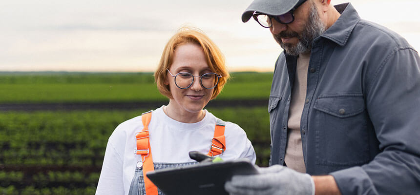 Zwei Fachkräfte auf dem Feld mit Tablet als Symbol für branchenspezifische ESG-Lösungen und zeitsparende Prozesse