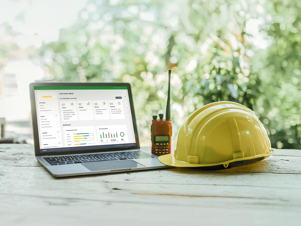 Branchenloesung Bauwirtschaft Software Helm, Walkie Talkie und Laptop mit leadity Software auf der Baustelle