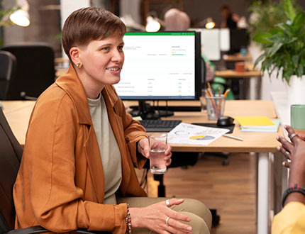 Lieferketten Risikoanalyse Datenbanken, Frau in großem Büro, Bildschirm mit leadity Software auf Schreibtisch