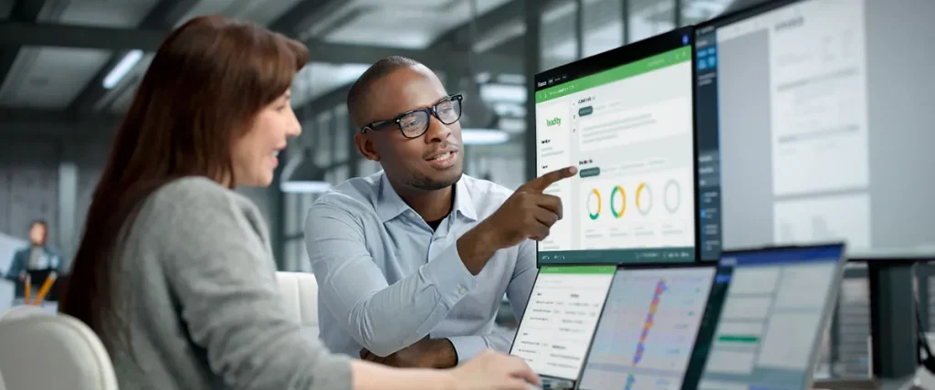 Titelbild: Die 5 besten ESG Softwares 2026 – Vergleich für den Mittelstand | zwei Personen sitzen vor Computer mit ESG-Software